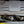 Load image into Gallery viewer, J&amp;L 16-22 Nissan Titan 5.6L Passenger Side Oil Separator 3.0 - Black Anodized
